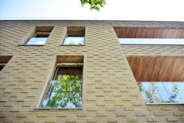 Mavi gökyüzü olan güneşli bir günde modern apartman binaları. Modern bir apartmanın cephesi