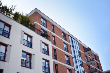 Mavi gökyüzü olan güneşli bir günde modern apartman binaları. Modern bir apartmanın cephesi