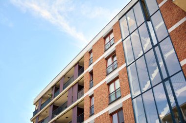 Mavi gökyüzü olan güneşli bir günde modern apartman binaları. Modern bir apartmanın cephesi