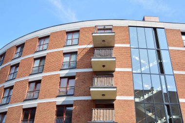 Mavi gökyüzü olan güneşli bir günde modern apartman binaları. Modern bir apartmanın cephesi