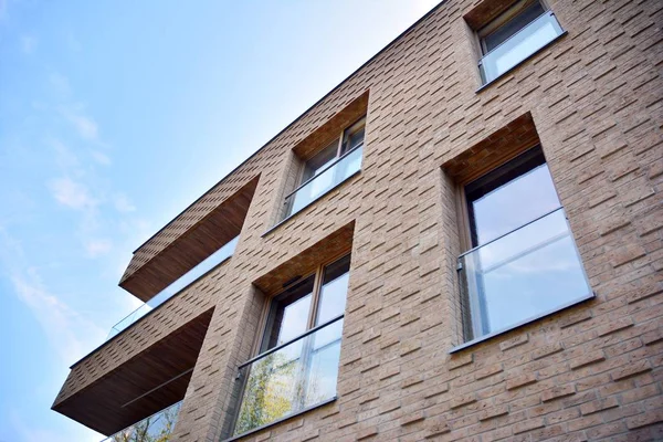 Mavi gökyüzü olan güneşli bir günde modern apartman binaları. Modern bir apartmanın cephesi