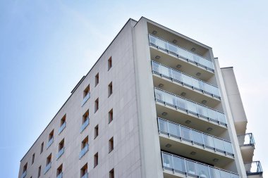 Mavi gökyüzü olan güneşli bir günde modern apartman binaları. Modern bir apartmanın cephesi