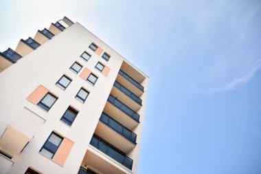 Mavi gökyüzü olan güneşli bir günde modern apartman binaları. Modern bir apartmanın cephesi