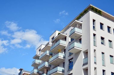 Mavi gökyüzü olan güneşli bir günde modern apartman binaları. Modern bir apartmanın cephesi