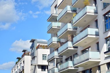 Mavi gökyüzü olan güneşli bir günde modern apartman binaları. Modern bir apartmanın cephesi
