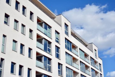 Mavi gökyüzü olan güneşli bir günde modern apartman binaları. Modern bir apartmanın cephesi