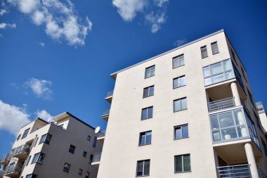 Mavi gökyüzü olan güneşli bir günde modern apartman binaları. Modern bir apartmanın cephesi