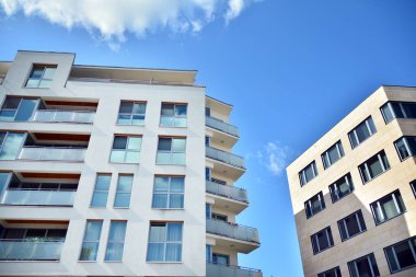 Mavi gökyüzü olan güneşli bir günde modern apartman binaları. Modern bir apartmanın cephesi