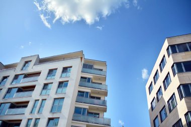 Mavi gökyüzü olan güneşli bir günde modern apartman binaları. Modern bir apartmanın cephesi