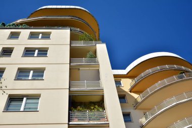 Mavi gökyüzü olan güneşli bir günde modern apartman binaları. Modern bir apartmanın cephesi