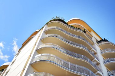 Mavi gökyüzü olan güneşli bir günde modern apartman binaları. Modern bir apartmanın cephesi