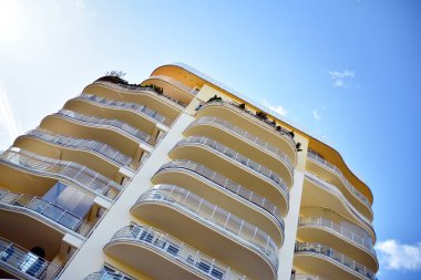 Mavi gökyüzü olan güneşli bir günde modern apartman binaları. Modern bir apartmanın cephesi