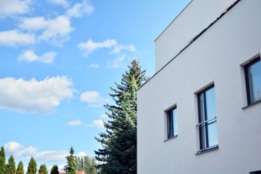 Mavi gökyüzü olan güneşli bir günde modern apartman binaları. Modern bir apartmanın cephesi