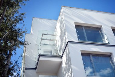 Mavi gökyüzü olan güneşli bir günde modern apartman binaları. Modern bir apartmanın cephesi