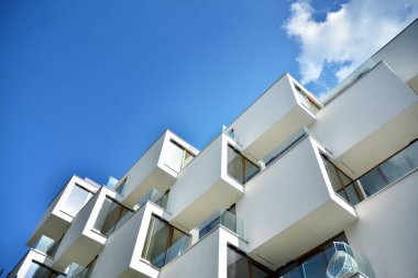 Mavi gökyüzü olan güneşli bir günde modern apartman binaları. Modern bir apartmanın cephesi