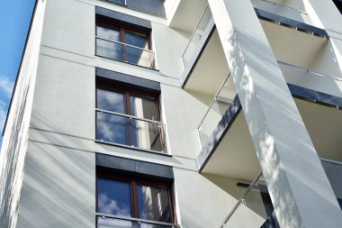Mavi gökyüzü olan güneşli bir günde modern apartman binaları. Modern bir apartmanın cephesi