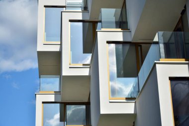 Mavi gökyüzü olan güneşli bir günde modern apartman binaları. Modern bir apartmanın cephesi