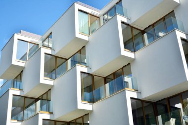 Mavi gökyüzü olan güneşli bir günde modern apartman binaları. Modern bir apartmanın cephesi