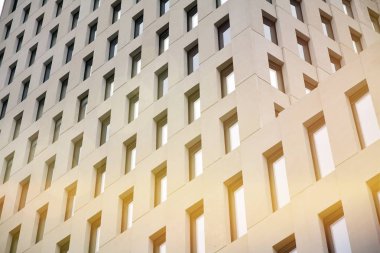 Modern ofis binası detayı. Güneş ışığı ile modernist brutalist tarzı bina yüzeyinin cephesinde geometrik açısal beton pencerelerperspektif görünümü.