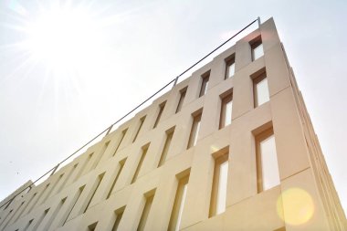 Modern ofis binası detayı. Güneş ışığı ile modernist brutalist tarzı bina yüzeyinin cephesinde geometrik açısal beton pencerelerperspektif görünümü.
