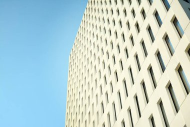 Modern ofis binası detayı. Modernist brutalist tarzı binanın cephesinde geometrik açısal beton pencerelerin perspektif görünümü. 