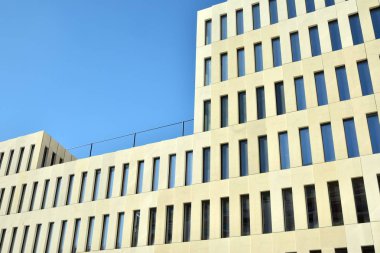 Modern ofis binası detayı. Modernist brutalist tarzı binanın cephesinde geometrik açısal beton pencerelerin perspektif görünümü. 