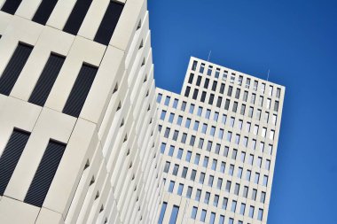 Modern ofis binası detayı. Modernist brutalist tarzı binanın cephesinde geometrik açısal beton pencerelerin perspektif görünümü. 
