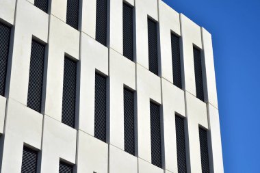 Modern ofis binası detayı. Modernist brutalist tarzı binanın cephesinde geometrik açısal beton pencerelerin perspektif görünümü. 