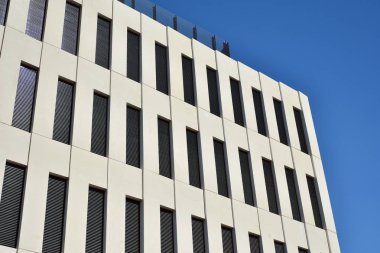 Modern ofis binası detayı. Modernist brutalist tarzı binanın cephesinde geometrik açısal beton pencerelerin perspektif görünümü. 