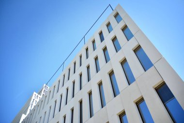 Modern ofis binası detayı. Modernist brutalist tarzı binanın cephesinde geometrik açısal beton pencerelerin perspektif görünümü. 