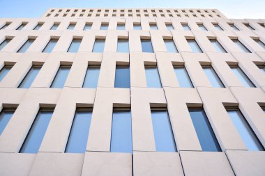 Modern ofis binası detayı. Modernist brutalist tarzı binanın cephesinde geometrik açısal beton pencerelerin perspektif görünümü. 