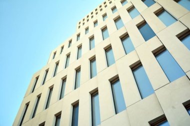 Modern ofis binası detayı. Modernist brutalist tarzı binanın cephesinde geometrik açısal beton pencerelerin perspektif görünümü. 
