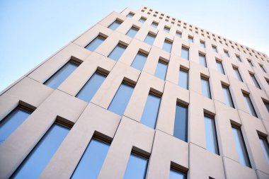 Modern ofis binası detayı. Modernist brutalist tarzı binanın cephesinde geometrik açısal beton pencerelerin perspektif görünümü. 