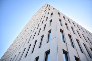 Modern ofis binası detayı. Modernist brutalist tarzı binanın cephesinde geometrik açısal beton pencerelerin perspektif görünümü. 