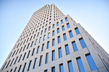 Modern ofis binası detayı. Modernist brutalist tarzı binanın cephesinde geometrik açısal beton pencerelerin perspektif görünümü. 