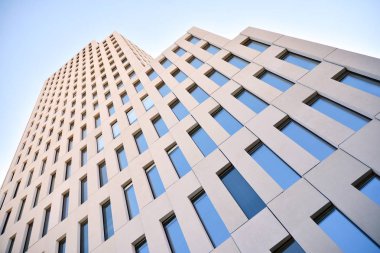 Modern ofis binası detayı. Modernist brutalist tarzı binanın cephesinde geometrik açısal beton pencerelerin perspektif görünümü. 