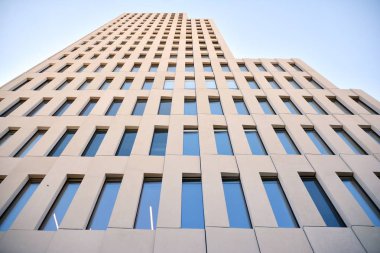 Modern ofis binası detayı. Modernist brutalist tarzı binanın cephesinde geometrik açısal beton pencerelerin perspektif görünümü. 