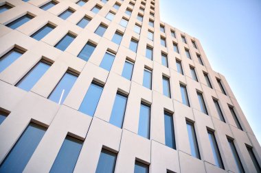 Modern ofis binası detayı. Modernist brutalist tarzı binanın cephesinde geometrik açısal beton pencerelerin perspektif görünümü. 