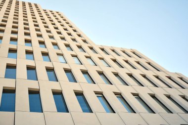 Modern ofis binası detayı. Modernist brutalist tarzı binanın cephesinde geometrik açısal beton pencerelerin perspektif görünümü. 