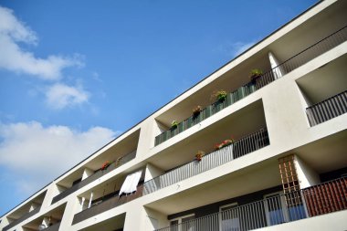 Mavi gökyüzü olan güneşli bir günde modern apartman binaları. Modern bir apartmanın cephesi