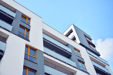 Mavi gökyüzü olan güneşli bir günde modern apartman binaları. Modern bir apartmanın cephesi