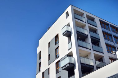 Mavi gökyüzü olan güneşli bir günde modern apartman binaları. Modern bir apartmanın cephesi