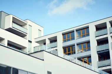 Mavi gökyüzü olan güneşli bir günde modern apartman binaları. Modern bir apartmanın cephesi