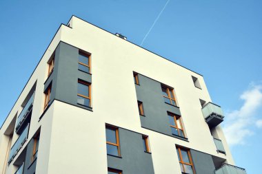 Mavi gökyüzü olan güneşli bir günde modern apartman binaları. Modern bir apartmanın cephesi