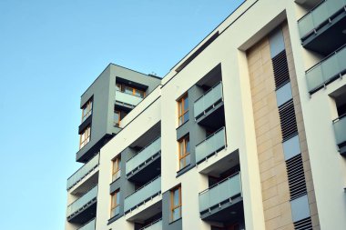 Mavi gökyüzü olan güneşli bir günde modern apartman binaları. Modern bir apartmanın cephesi