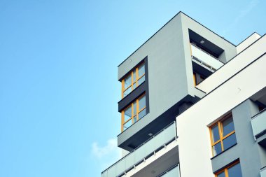 Mavi gökyüzü olan güneşli bir günde modern apartman binaları. Modern bir apartmanın cephesi