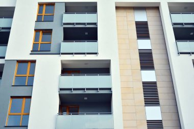 Mavi gökyüzü olan güneşli bir günde modern apartman binaları. Modern bir apartmanın cephesi