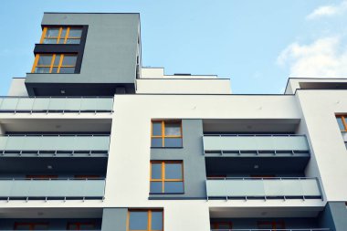 Mavi gökyüzü olan güneşli bir günde modern apartman binaları. Modern bir apartmanın cephesi