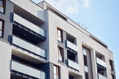 Mavi gökyüzü olan güneşli bir günde modern apartman binaları. Modern bir apartmanın cephesi