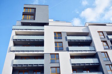 Mavi gökyüzü olan güneşli bir günde modern apartman binaları. Modern bir apartmanın cephesi